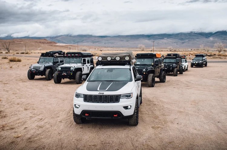 A lineup of overland Jeeps parked in the desert