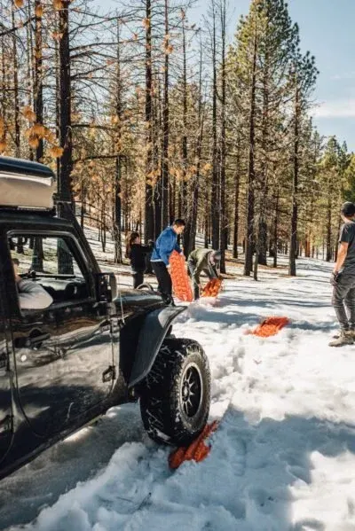 Jeep Wrangler with lots of Maxtrax being used in a snow recovery