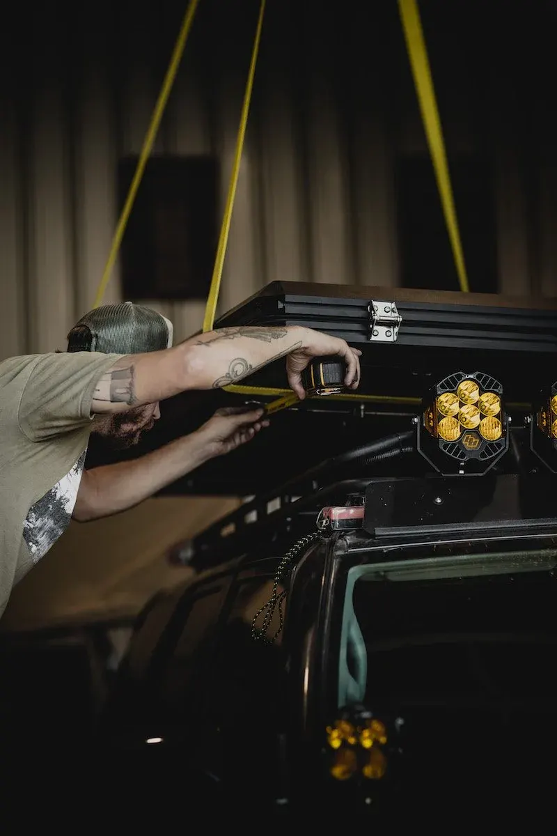 Person installing a light on a vehicle in a garage
