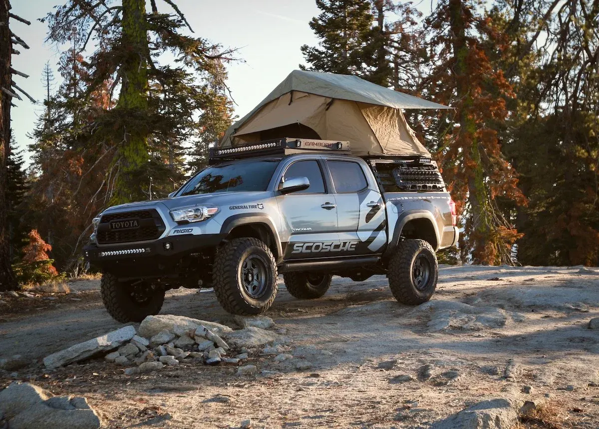 Toyota Tacoma with a rooftop tent in a pine forest