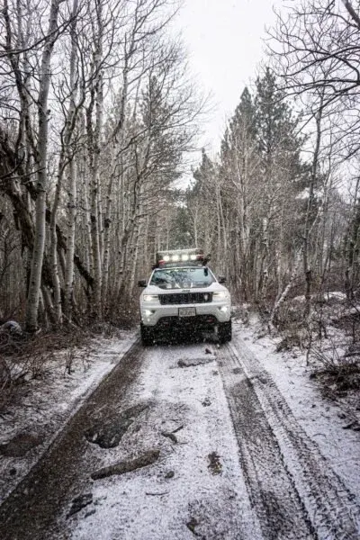 Jeep Grand Cherokee Trailhawk on a snowy trail with lots of trees