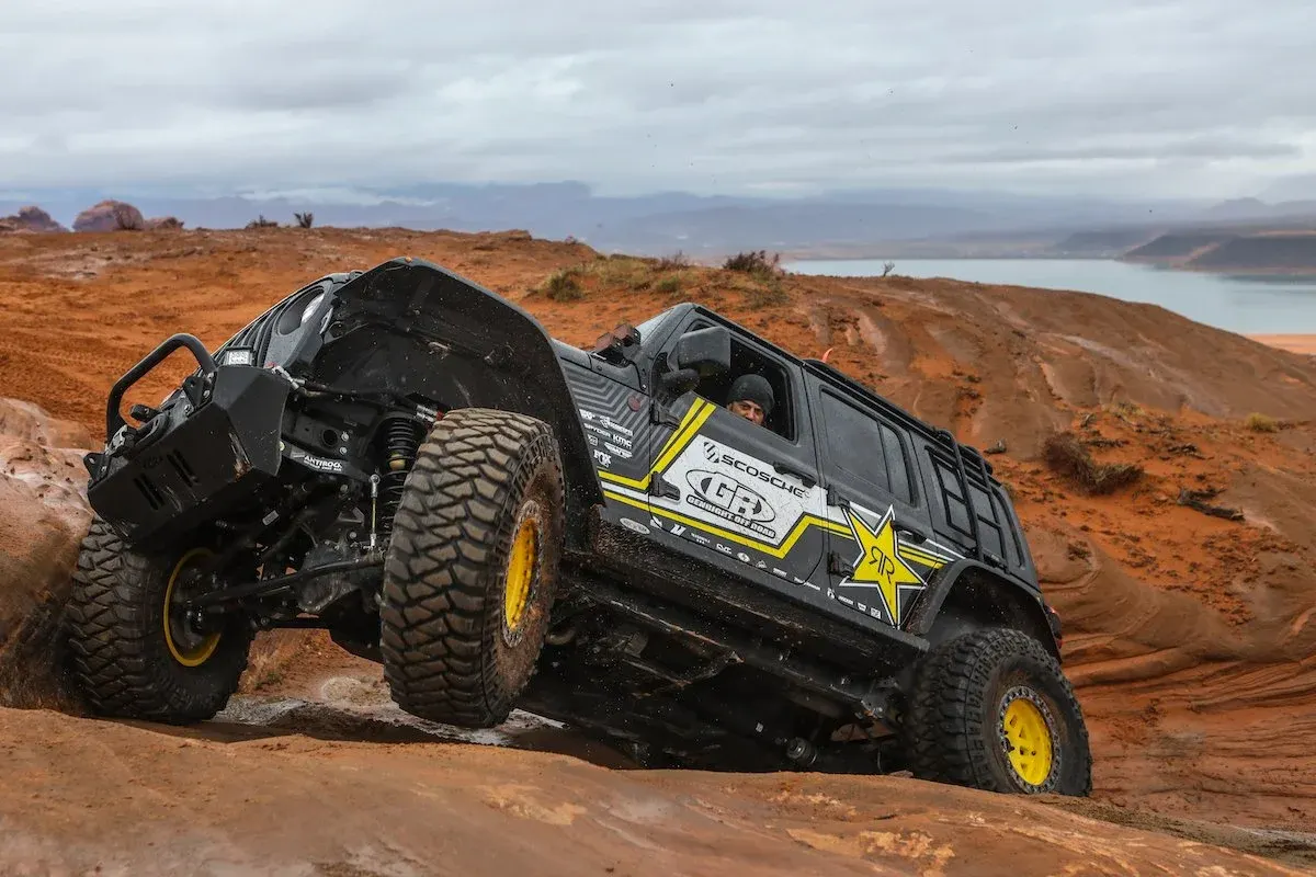 Black Jeep Wrangler JL crawling over red rock