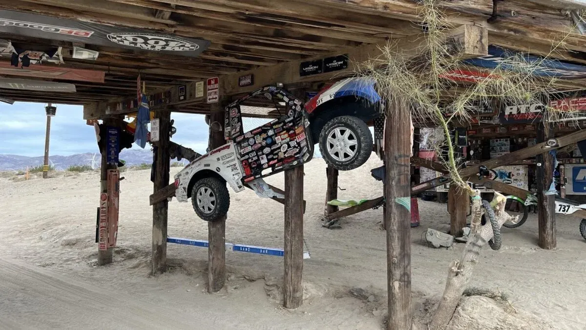 Racecar and trophy truck parts at an overpass