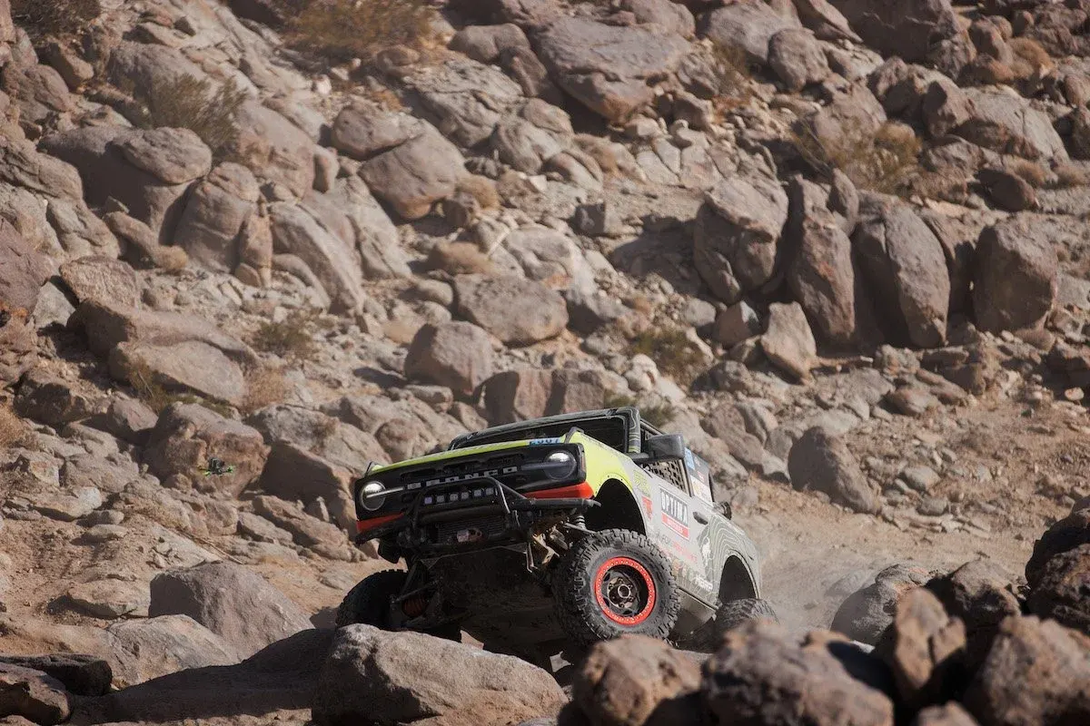 Ford Bronco race truck crawling through a boulder field