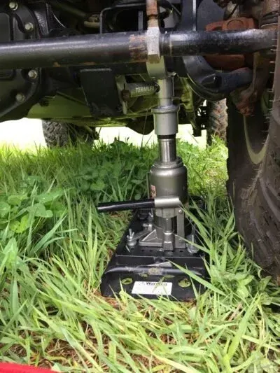 Safe Jack bottle jack lifting a vehicle on grass