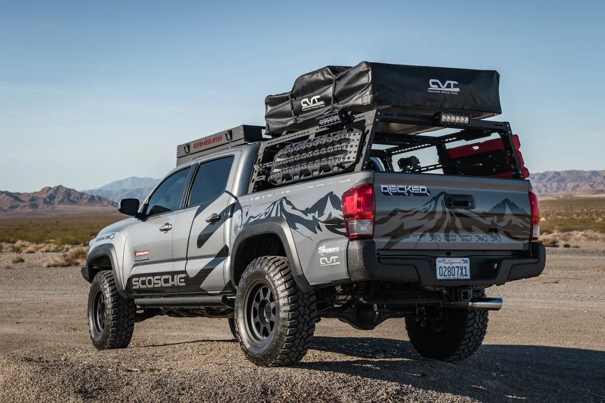 Rear view of a Toyota Tacoma with roof rack gear in the desert