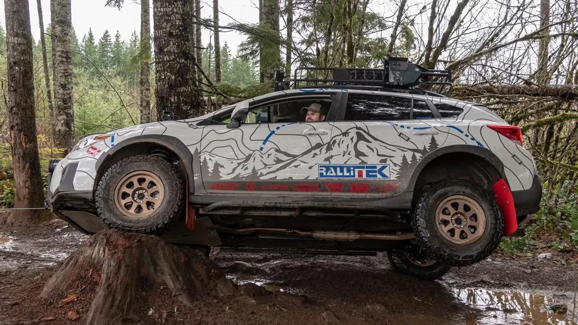 Subaru Crosstrek perched on a tree stump in the woods