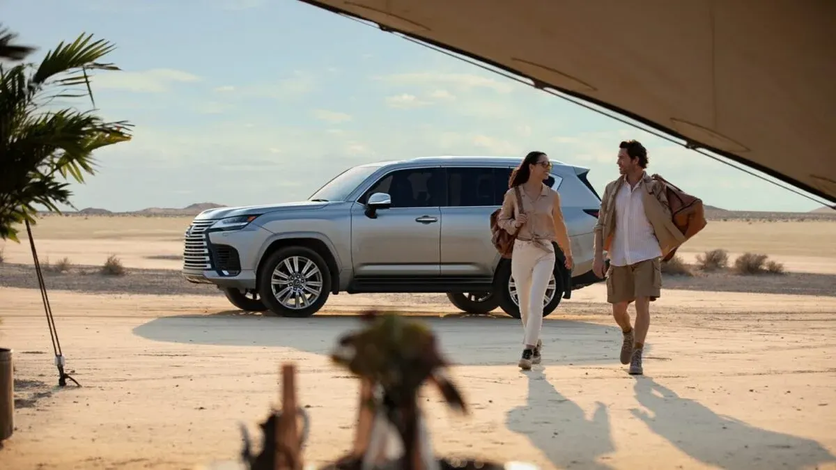 Couple walking away from a silver Lexus LX 600 in the desert