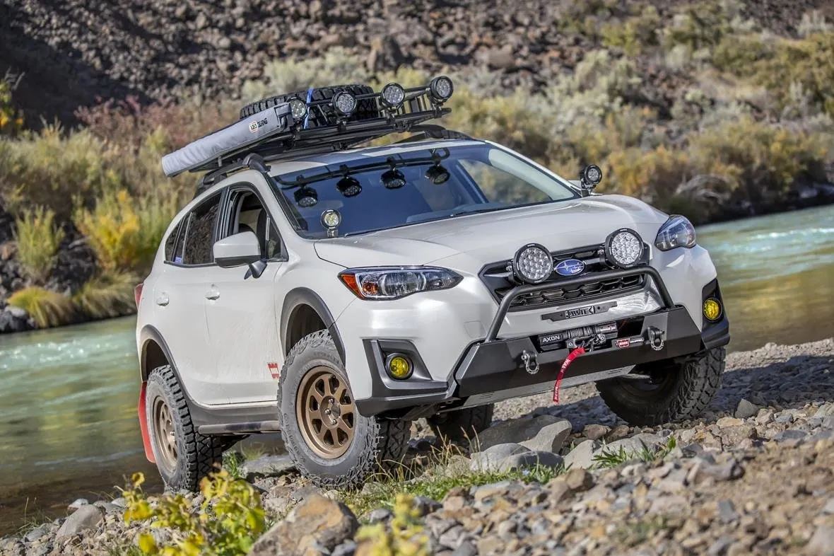 Subaru Crosstrek with lights parked beside a river