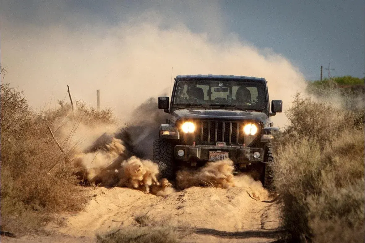Jeep Gladiator driving fast down a sandy trail